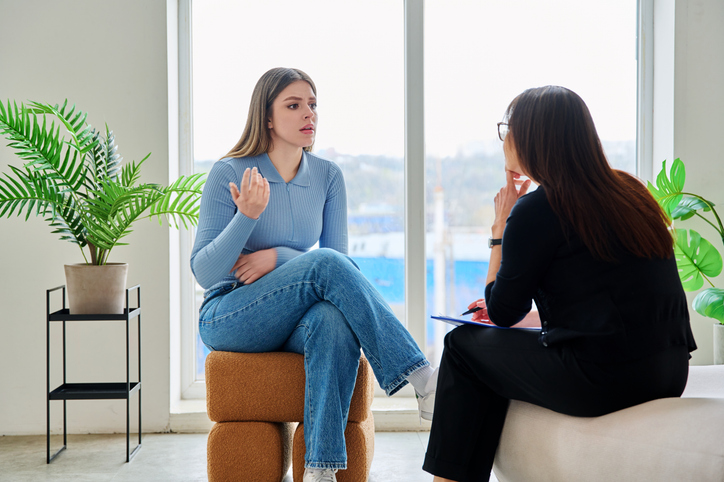 Young woman in a therapy session talking with a psychotherapist